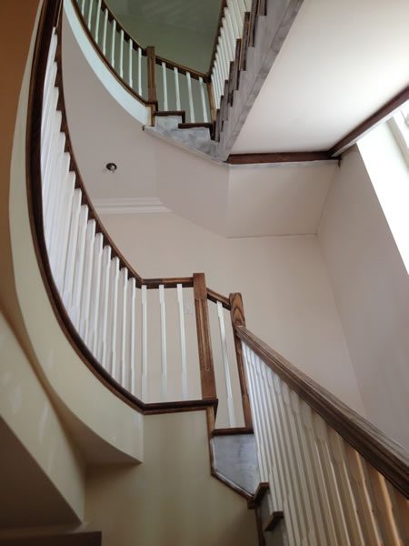 A curved staircase with painted balustrade and risers.