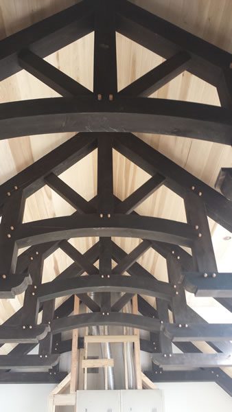 Exposed timber roof trusses finished by hand.